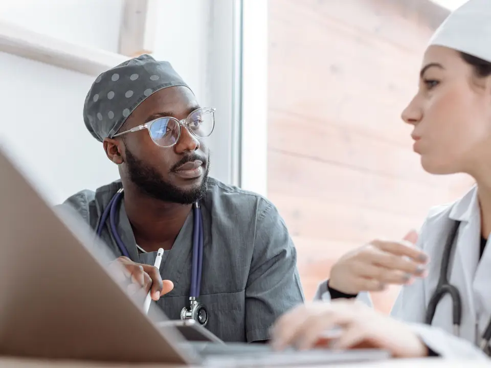 Stock photo: two clinicians talking at a desk